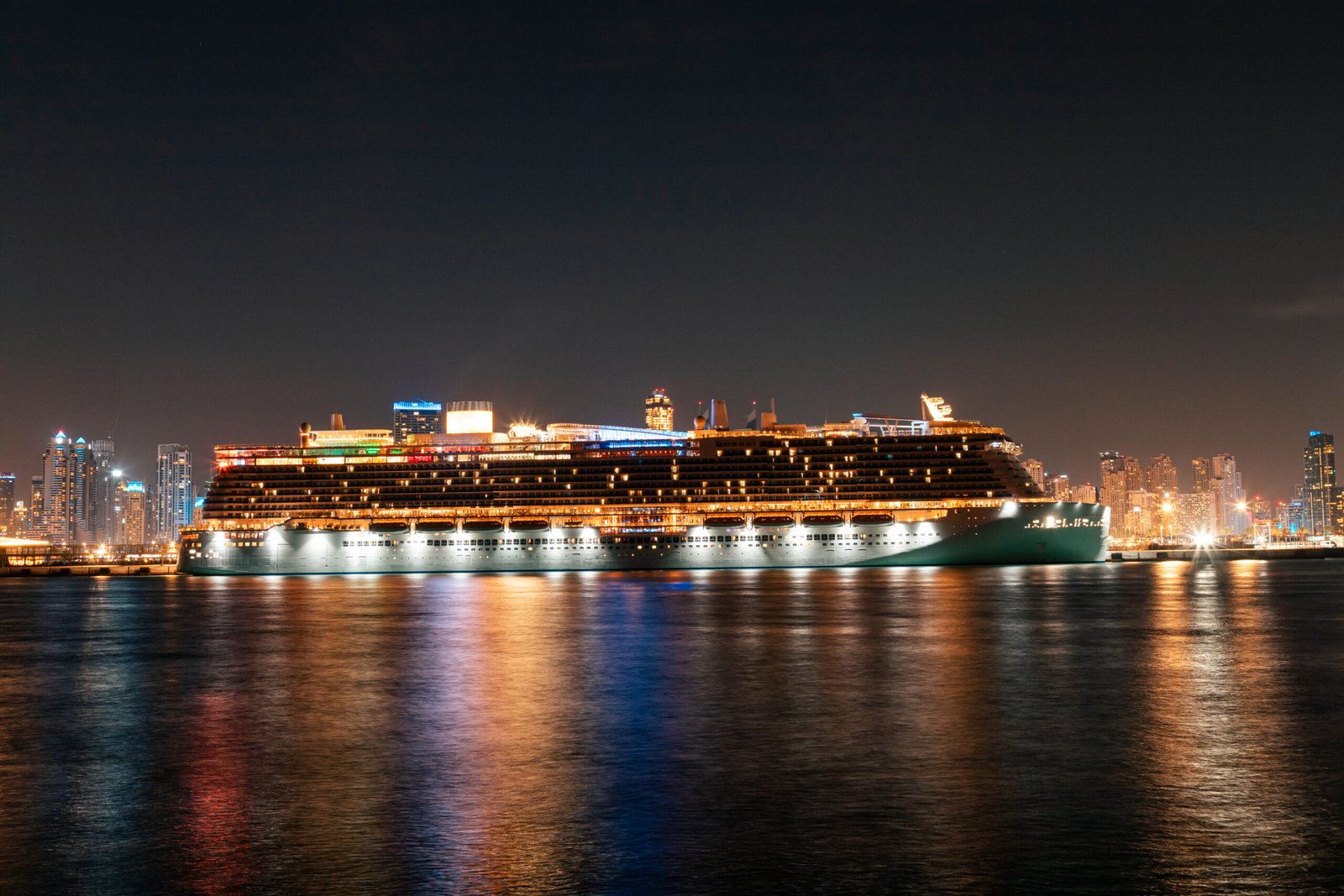 Cruise ship at Marina harbor at night in Dubai Cruise ship at Marina harbor at night seen from Palm Jumeirah island in Dubai